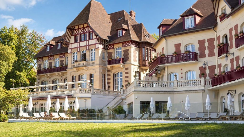 Façade du château et sa terrasse avec transats