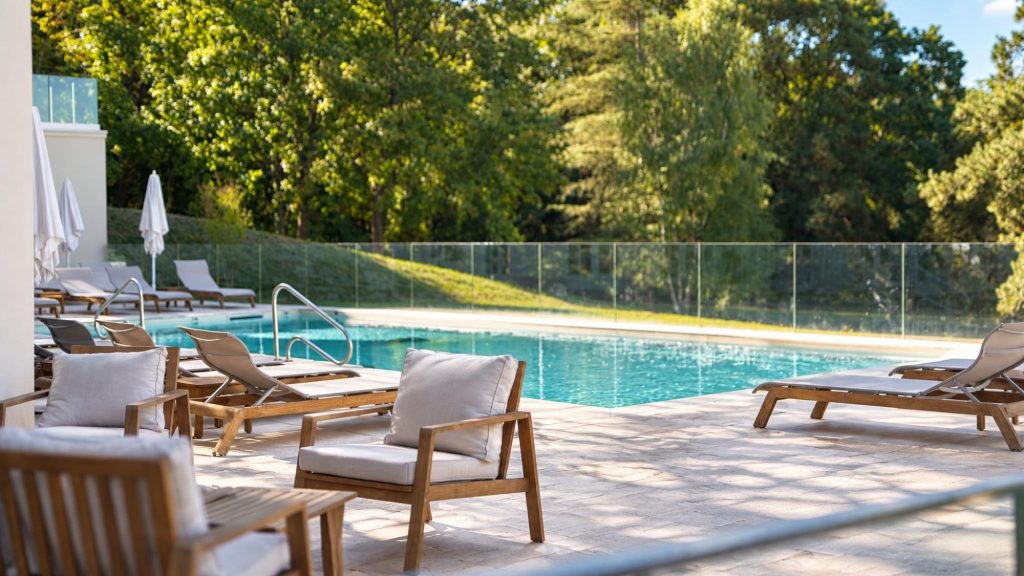 Fauteuils et piscine du château entourés d’arbres